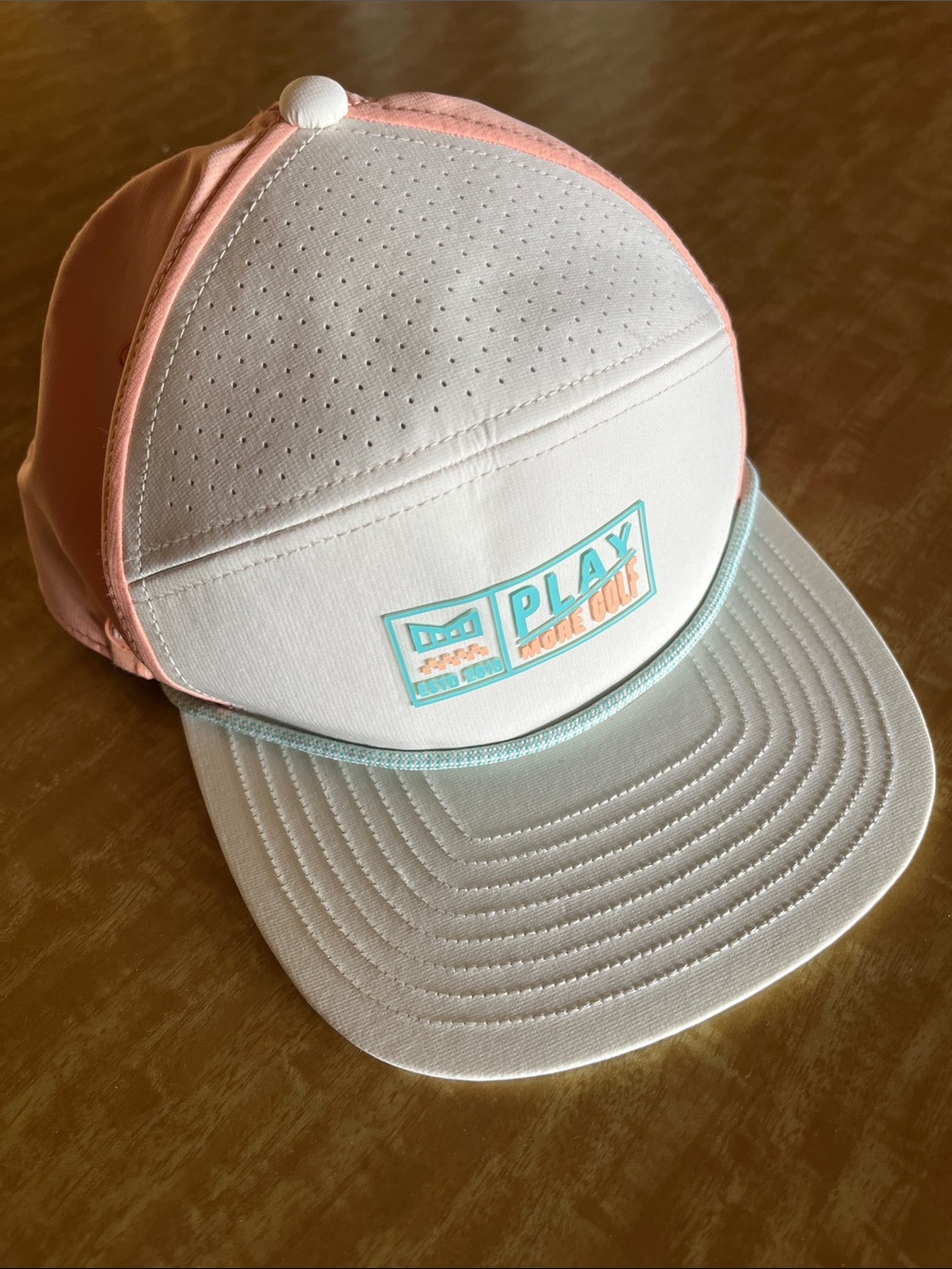 Melin PLAY Logo White and Peach Trucker Golf Hat with Teal Trim